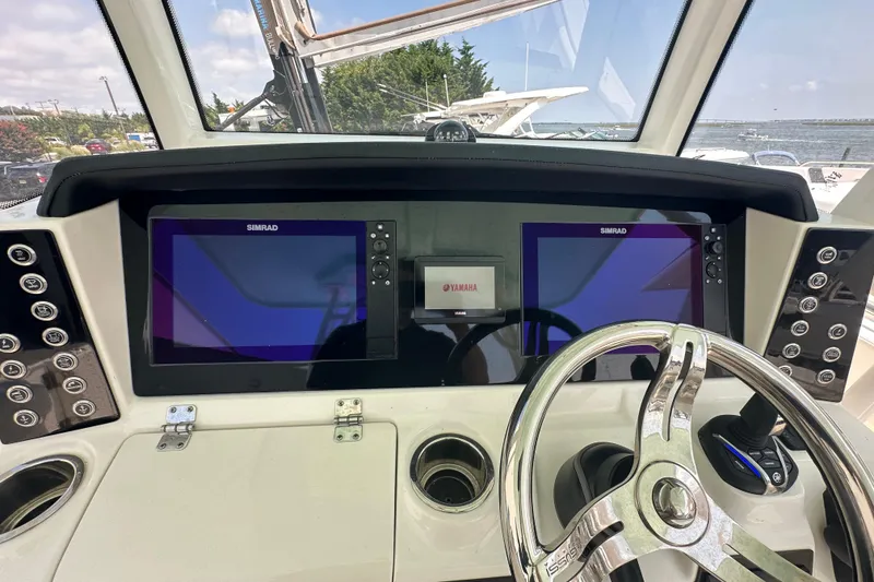Slide: The Image of 2023 Robalo R302 Center Console dashboard with dual Simrad displays and Yamaha controls. - 28
