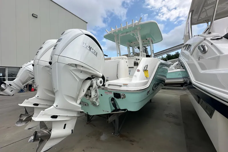 Slide: The Image of 2023 Robalo R302 Center Console boat with twin Yamaha engines, docked outdoors. - 3