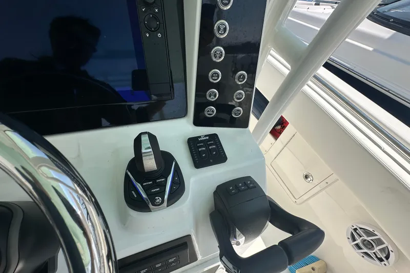 Slide: The Image of 2023 Robalo R302 Center Console helm with controls and steering wheel. - 30
