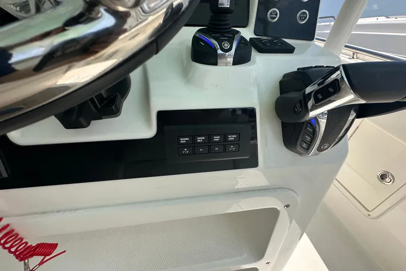 Slide: The Image of 2023 Robalo R302 Center Console boat dashboard with steering wheel and control panel. - 31