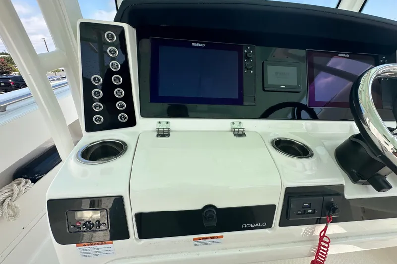 Slide: The Image of 2023 Robalo R302 Center Console dashboard with Simrad displays and control panel. - 32