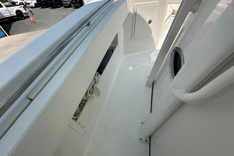 Slide: The Image of 2023 Robalo R302 Center Console boat interior with storage compartment and railing. - 33