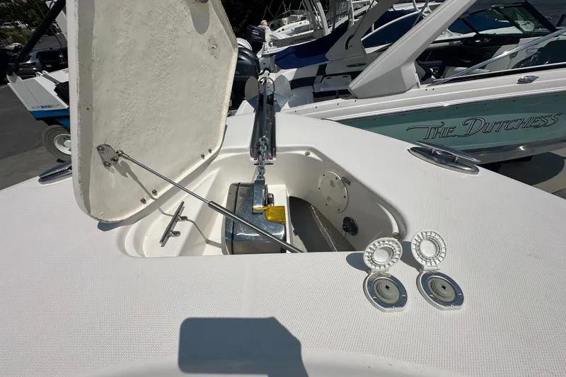 Slide: The Image of 2023 Robalo R302 Center Console anchor compartment with open hatch, showcasing marine hardware. - 34