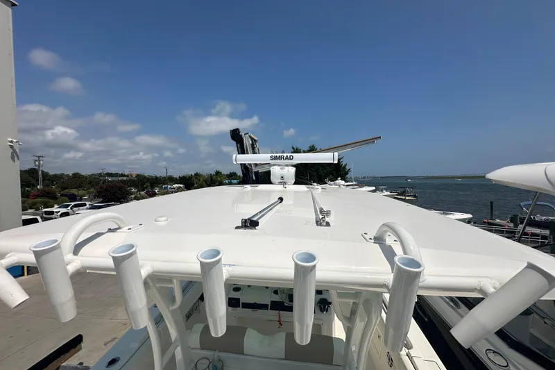 Slide: The Image of 2023 Robalo R302 Center Console boat with Simrad radar, docked by the waterfront. - 43