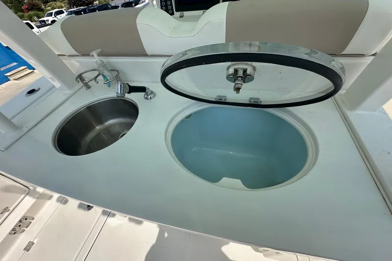 Slide: The Image of 2023 Robalo R302 Center Console boat sink and storage compartment. - 7