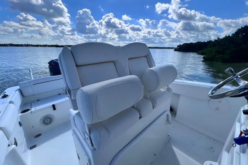 Slide: The Image of 2017 Sea Hunt Ultra 235 SE boat interior with plush seating and scenic water view. - 11