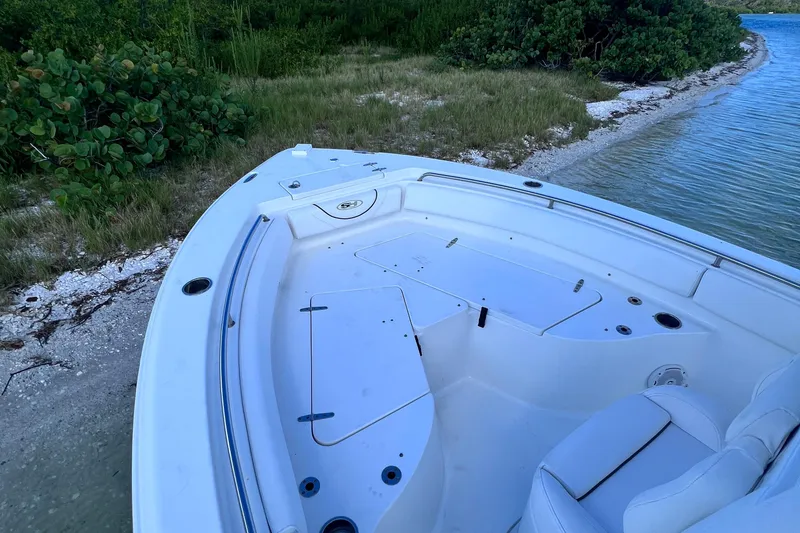 Slide: The Image of 2017 Sea Hunt Ultra 235 SE boat docked by a grassy shoreline. - 8