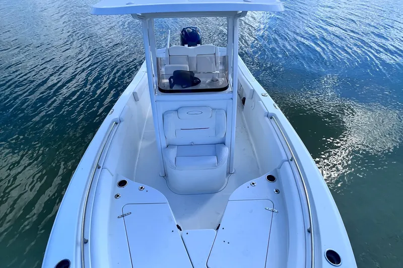 Slide: The Image of 2017 Sea Hunt Ultra 235 SE boat on calm water, showcasing spacious deck and seating. - 9