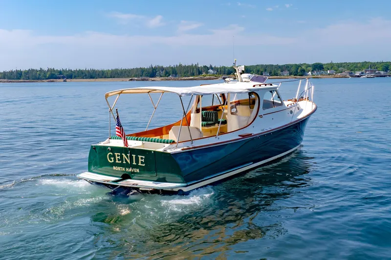 Slide: The Image of 1999 Hinckley Picnic Boat cruising on calm waters, displaying "Genie" and "North Haven." - 10