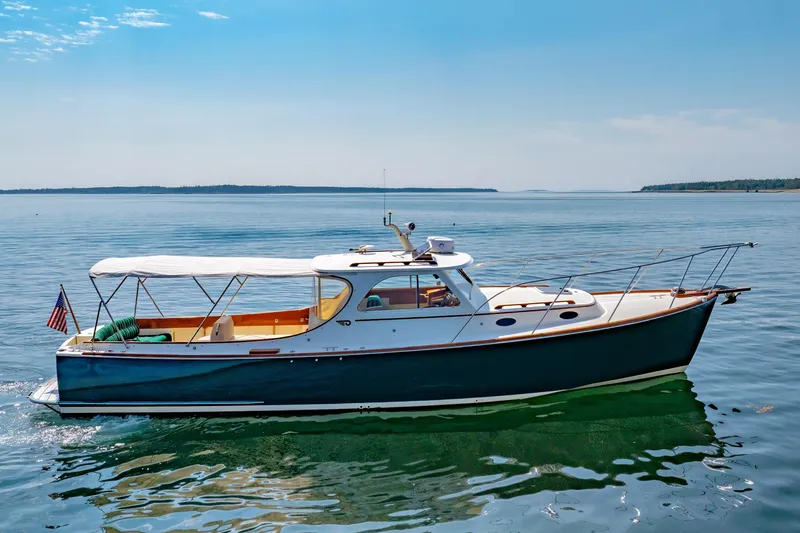 Slide: The Image of 1999 Hinckley Picnic Boat cruising on calm waters under a clear blue sky. - 11