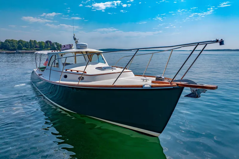 Slide: The Image of 1999 Hinckley Picnic Boat cruising on calm waters under a clear blue sky. - 16