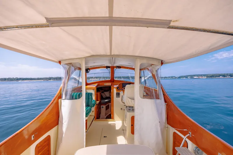 Slide: The Image of 1999 Hinckley Picnic Boat interior with canopy, cruising on calm blue waters. - 19