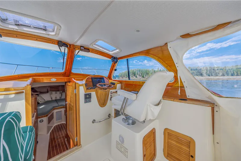 Slide: The Image of 1999 Hinckley Picnic Boat interior with wooden accents and scenic water view. - 27