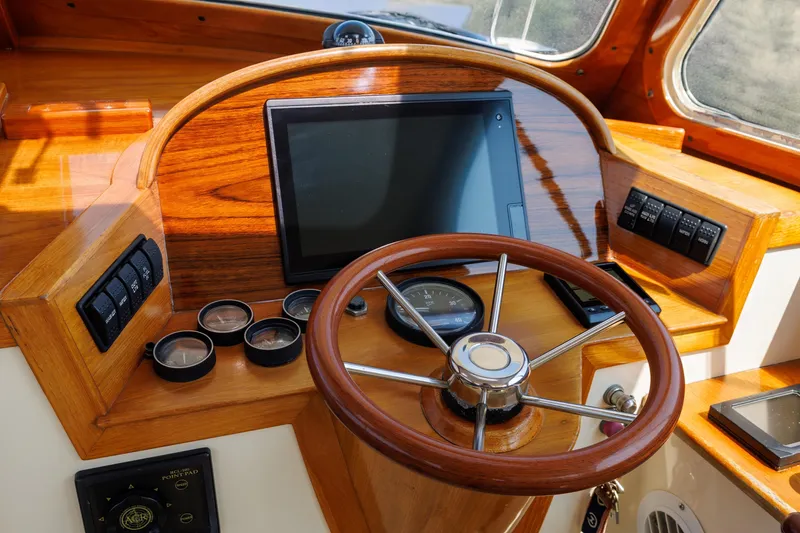 Slide: The Image of 1999 Hinckley Picnic Boat helm with wooden steering wheel and navigation instruments. - 29