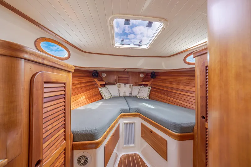 Slide: The Image of 1999 Hinckley Picnic Boat interior with wooden finish and cozy sleeping area. - 37
