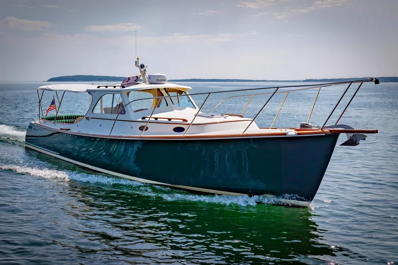 Slide: The Image of 1999 Hinckley Picnic Boat cruising on open water under a clear sky. - 4