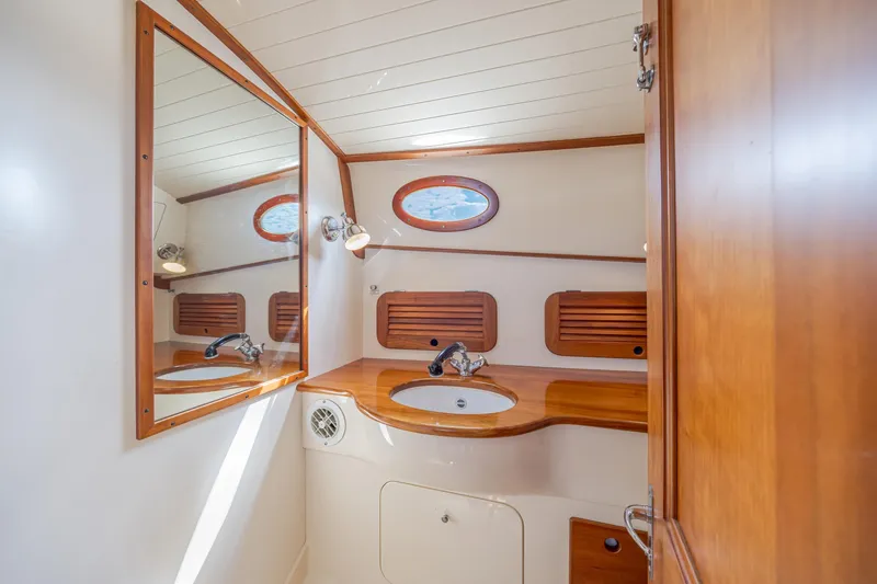 Slide: The Image of 1999 Hinckley Picnic Boat bathroom with wooden accents and oval window. - 40