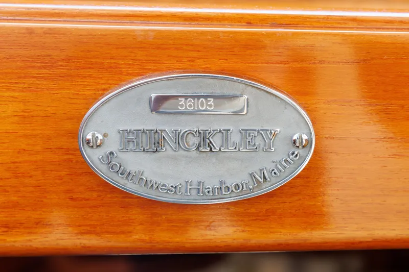 Slide: The Image of Hinckley Picnic Boat 1999 nameplate, Southwest Harbor, Maine, on polished wood surface. - 42