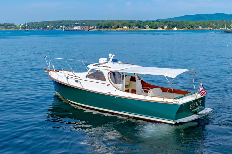 Slide: The Image of 1999 Hinckley Picnic Boat cruising on calm waters with scenic shoreline backdrop. - 9