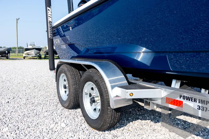 Slide: The Image of 2026 Pathfinder 2200 TRS boat on trailer, close-up of wheels and hull. - 15