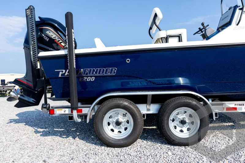 Slide: The Image of 2026 Pathfinder 2200 TRS boat on trailer, featuring Yamaha engine, parked on gravel. - 16
