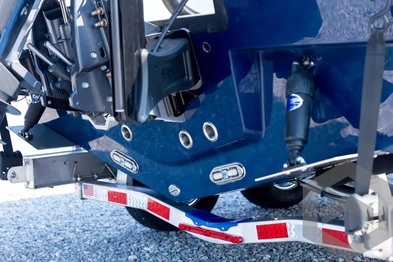Slide: The Image of 2026 Pathfinder 2200 TRS boat trailer hitch and motor detail on gravel. - 18