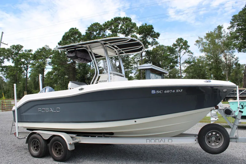Slide: The Image of 2018 Robalo R200 Center Console boat on trailer, parked outdoors. - 16