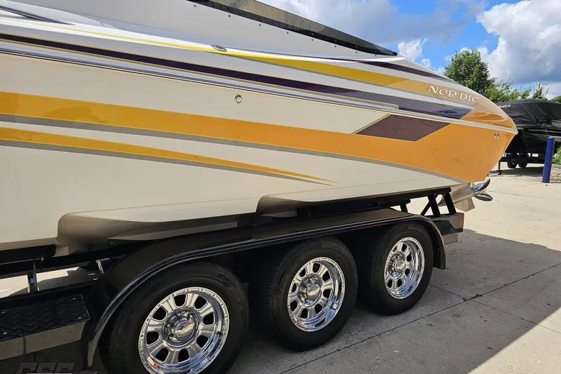 Slide: The Image of 2008 Nordic Powerboats 35 Flame MCOB on trailer, featuring vibrant yellow and purple accents. - 28