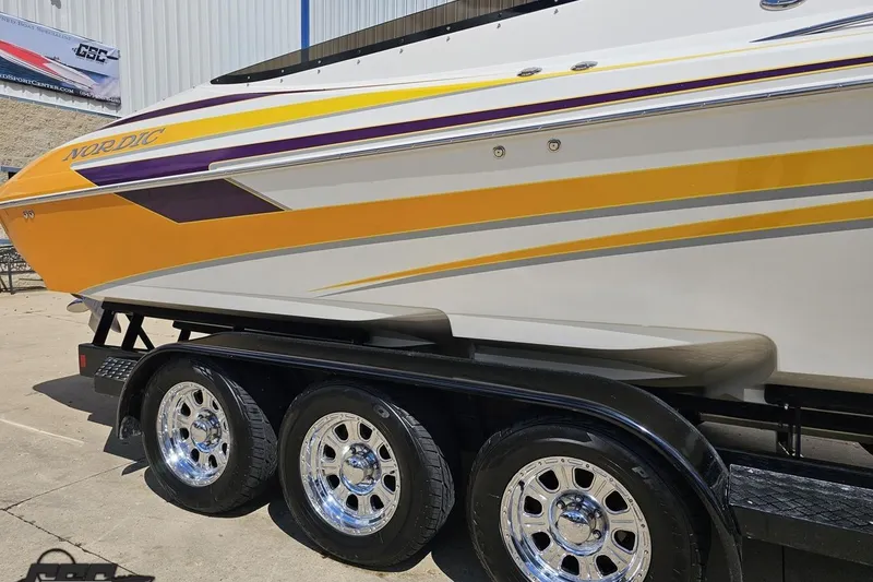Slide: The Image of 2008 Nordic Powerboats 35 Flame MCOB with vibrant yellow and purple accents on a trailer. - 4