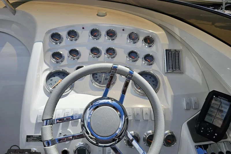 Slide: The Image of 2008 Nordic Powerboats 35 Flame MCOB dashboard with gauges, steering wheel, and Garmin device. - 75