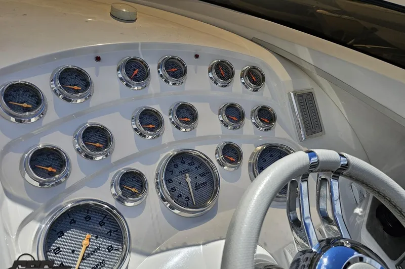 Slide: The Image of Dashboard of 2008 Nordic Powerboats 35 Flame MCOB with multiple gauges and steering wheel. - 76