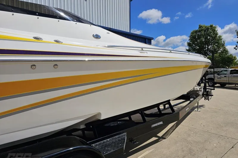Slide: The Image of 2008 Nordic Powerboats 35 Flame MCOB on trailer, featuring sleek yellow and purple accents. - 9