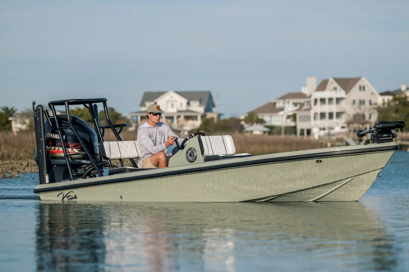 Slide: The Image of Man steering 2025 Vtech 18 boat on calm water near residential area. - 0