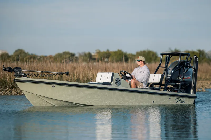 Slide: The Image of 2025 Vtech 18 boat on calm water, person steering, natural background. - 1