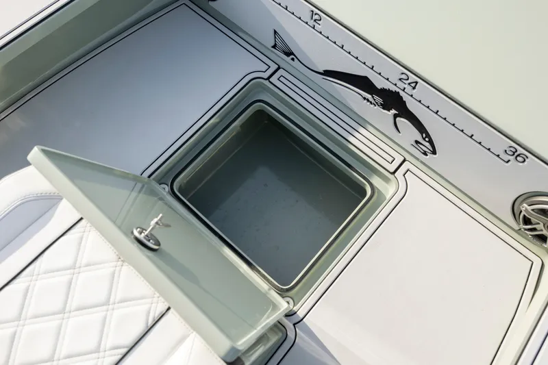 Slide: The Image of Open storage compartment on Vtech 18 boat, featuring fish measurement scale, 2025 model. - 24