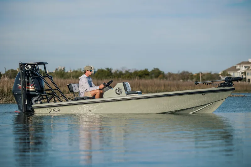 Slide: The Image of 2025 Vtech 18 boat on calm water, person steering, scenic background. - 5