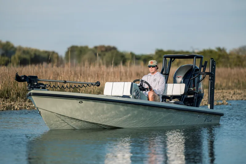 Slide: The Image of Man operating a 2025 Vtech 18 boat on a calm lake. - 7
