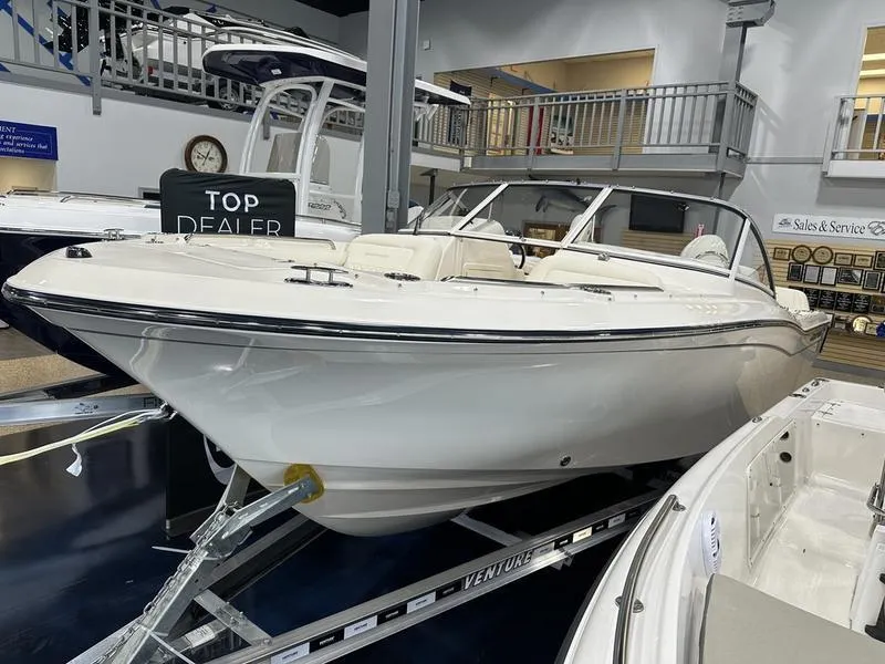 Slide: The Image of 2025 Grady-White Freedom 215 boat docked, featuring luxurious seating and sleek design. - 12