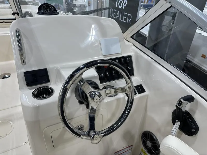 Slide: The Image of 2025 Grady-White Freedom 215 boat docked at a marina under clear blue skies. - 5