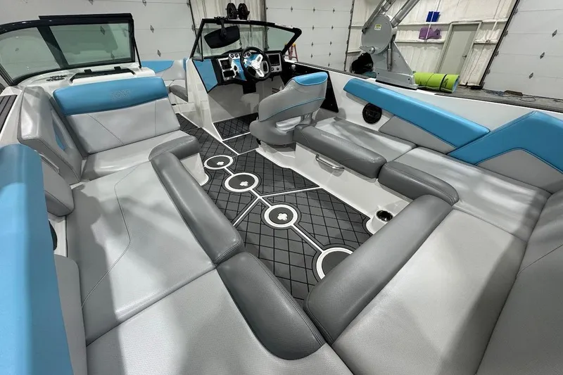 Slide: The Image of 2019 MasterCraft NXT22 boat interior with gray and blue seating, diamond-patterned flooring. - 12