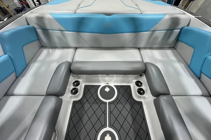Slide: The Image of 2019 MasterCraft NXT22 interior with gray and blue seating, stylish flooring, and cup holders. - 15
