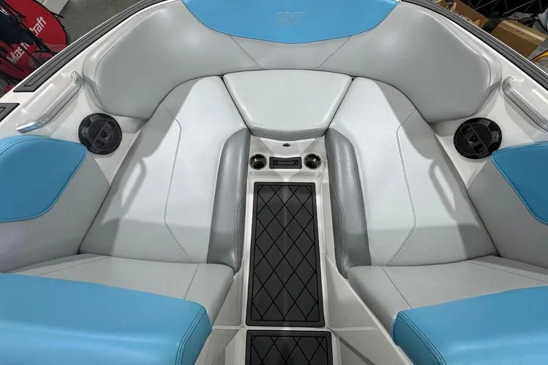 Slide: The Image of 2019 MasterCraft NXT22 interior with blue and gray seating, speaker, and cup holders. - 21