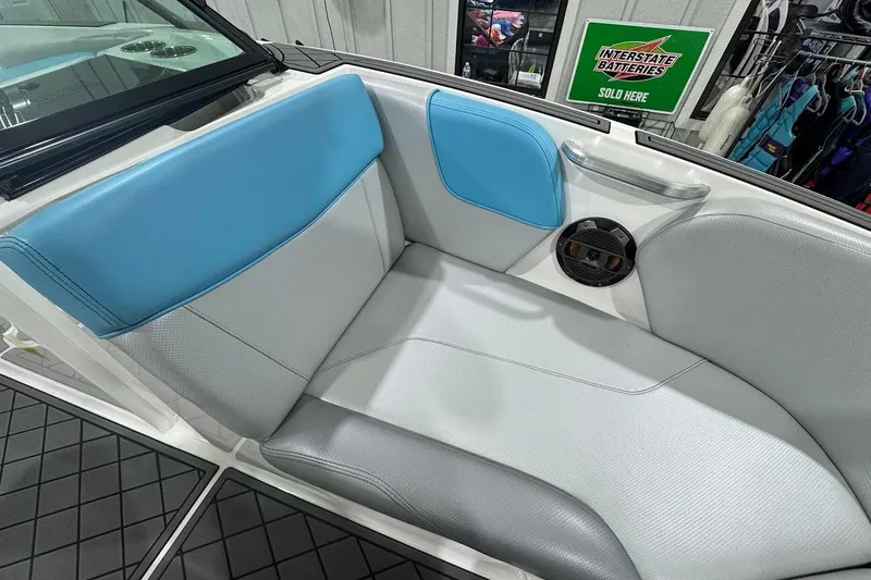 Slide: The Image of 2019 MasterCraft NXT22 boat interior with blue and gray seating, speaker, and textured flooring. - 22