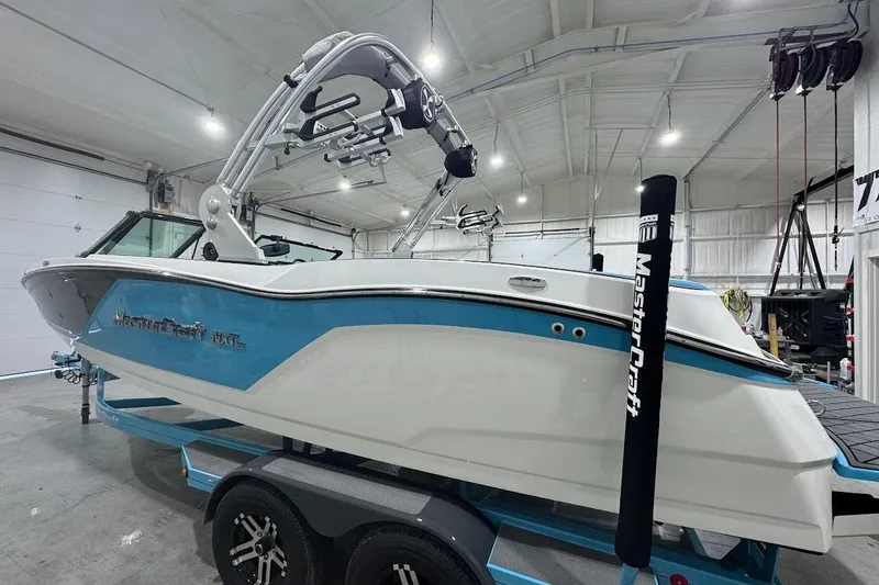 Slide: The Image of 2019 MasterCraft NXT22 boat in a garage, featuring a sleek white and blue design. - 3