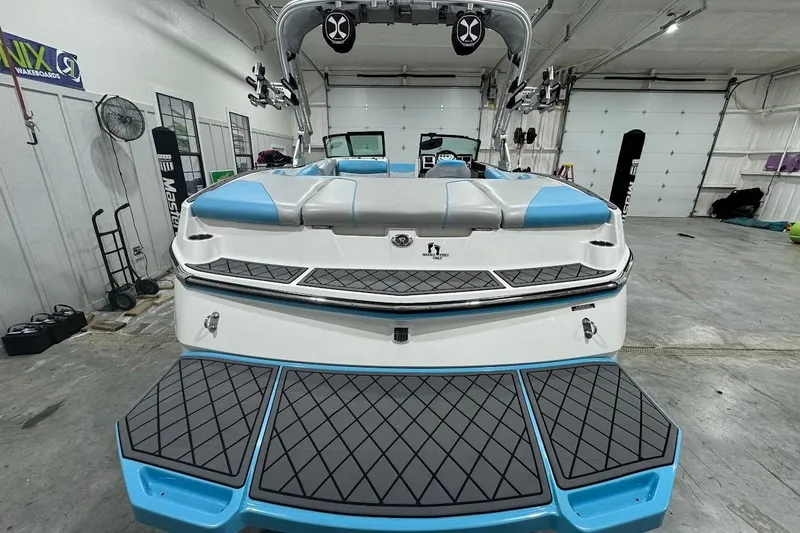 Slide: The Image of 2019 MasterCraft NXT22 boat in a garage, showcasing rear deck and seating. - 4
