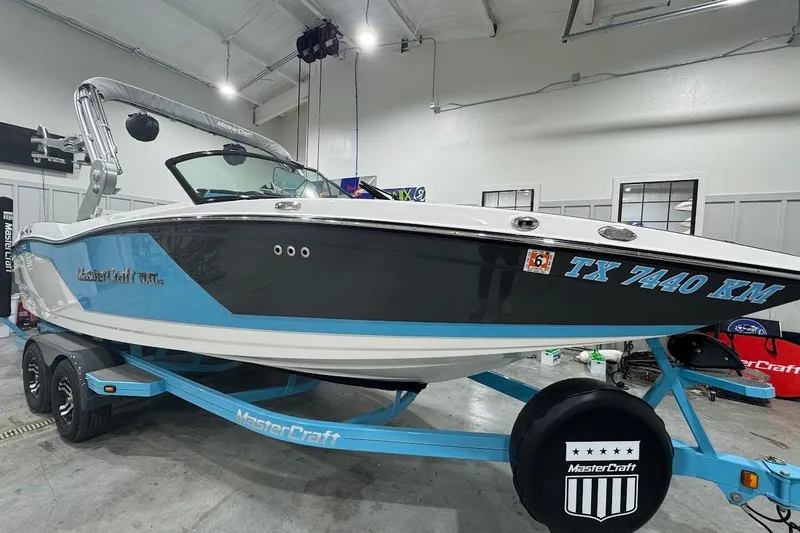 Slide: The Image of 2019 MasterCraft NXT22 boat on trailer in indoor showroom, side view. - 8