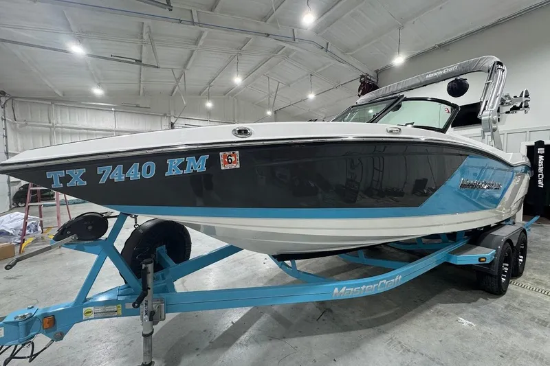 Slide: The Image of 2019 MasterCraft NXT22 boat interior with blue and gray seating in a garage setting. - 9
