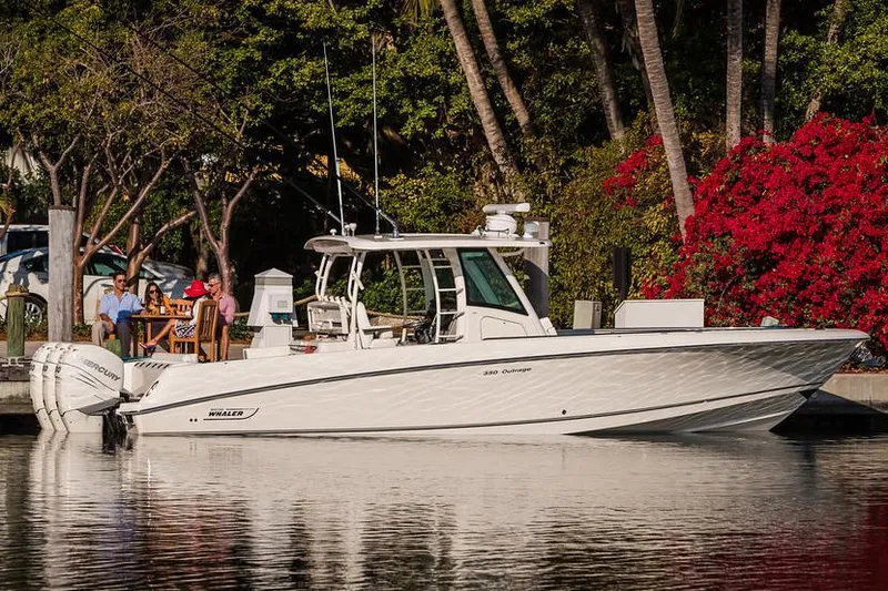 Slide: The Image of Manufacturer Provided Image: 2018 Boston Whaler 350 Outrage docked near a lush, scenic shoreline. - 2