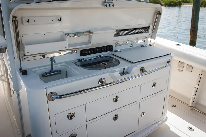 Slide: The Image of Manufacturer Provided Image: 2018 Boston Whaler 350 Outrage boat galley with sink and storage drawers. - 9