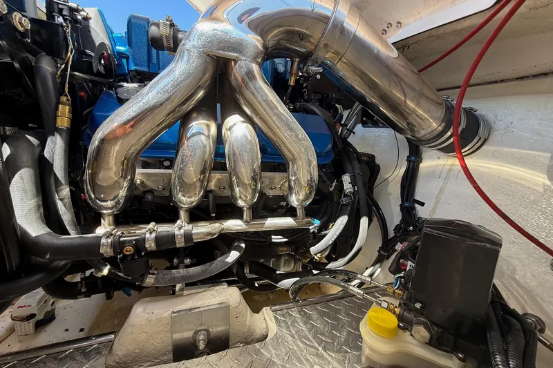 Slide: The Image of Engine compartment of a 2002 Donzi 22 Classic boat, featuring polished exhaust headers. - 5